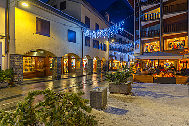 View of restaurants and bars on via Roma at dusk, Courmayeur, Aosta Valley, Italy, Europe