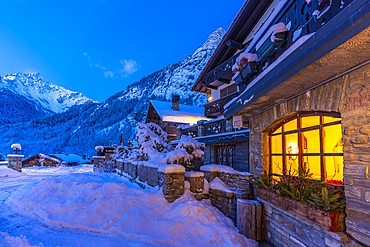 View of chalets and snow covered mountains in Courmayeur before dawn during winter, Courmayeur, Aosta Valley, Italy, Europe