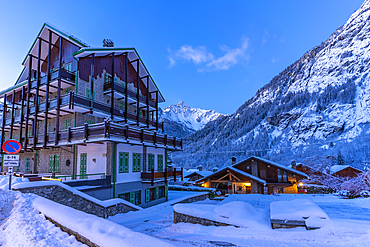 View of chalets and snow covered mountains in Courmayeur before dawn during winter, Courmayeur, Aosta Valley, Italy, Europe