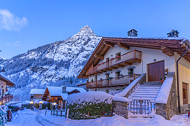 View of chalets and snow covered mountains in Courmayeur before dawn during winter, Courmayeur, Aosta Valley, Italy, Europe