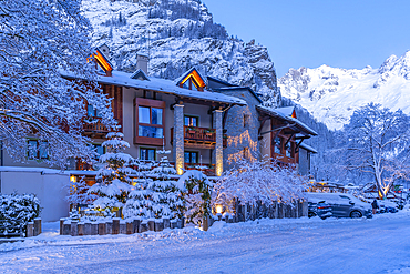 View of hotel and snow covered mountains in Courmayeur before dawn during winter, Courmayeur, Aosta Valley, Italy, Europe