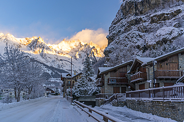 View of hotels, chalets and snow covered mountains in Courmayeur at sunrise during winter, Courmayeur, Aosta Valley, Italy, Europe