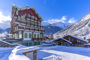 View of chalets and snow covered mountains in Courmayeur at sunrise during winter, Courmayeur, Aosta Valley, Italy, Europe