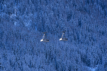 Snow covered trees, mountains and cable cars from Courmayeur to Plan Chécrouit viewed from Courmayeur during winter, Courmayeur, Aosta Valley, Italy, Europe