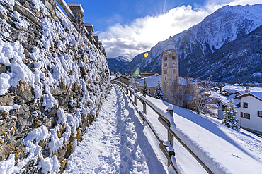 View of snow covered mountains, rooftops and Church of Saint Pantalon in Courmayeur during winter, Courmayeur, Aosta Valley, Italy, Europe