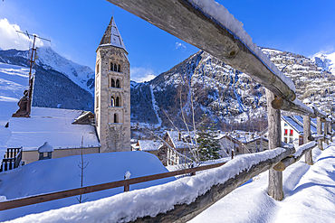 View of snow covered mountains, rooftops and Church of Saint Pantalon in Courmayeur during winter, Courmayeur, Aosta Valley, Italy, Europe