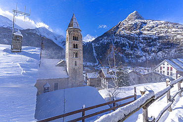 View of snow covered mountains, rooftops and Church of Saint Pantalon in Courmayeur during winter, Courmayeur, Aosta Valley, Italy, Europe