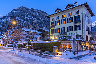 View of town centre and snow covered mountains in background at dusk, Courmayeur, Aosta Valley, Italy, Europe