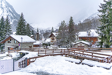 View of snow covered wooden houses and church in Entrèves during winter, Entrèves, Aosta Valley, Italy, Europe