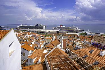 View of cruise ships in port and terrakotta rooftops in Alfama, Alfama District, Lisbon, Portugal, Europe