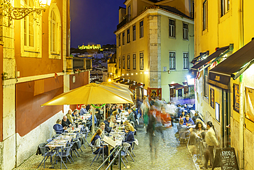 View of cafe and restaurant and steps with Lisbon Castle in background at dusk, Lisbon, Portugal, Europe