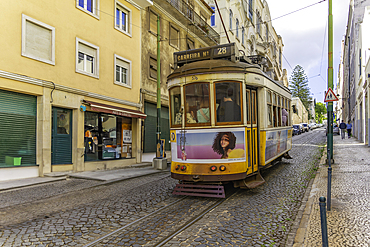 View of vintage yellow No28 tram on a sunny day in the Alfama District, Lisbon, Portugal, Europe