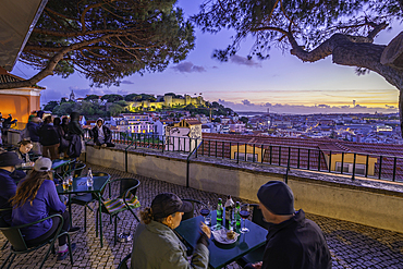 Panoramic view of Lisbon Castle from Miradouro da Senhora do Monte scenic point at dusk in the Alfama District, Lisbon, Portugal, Europe