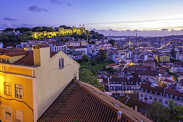 Panoramic view of Lisbon Castle from Miradouro da Senhora do Monte scenic point at dusk in the Alfama District, Lisbon, Portugal, Europe