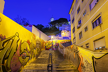 View of colourful graffiti and steps leading to Church of Our Lady of Grace at dusk in the Alfama District, Lisbon, Portugal, Europe