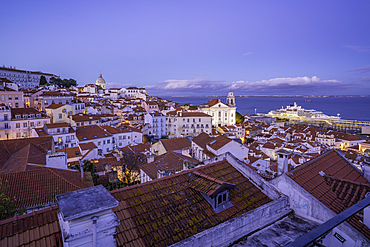 View of colourful buildings and red rooftops at dusk in the Alfama District, Lisbon, Portugal, Europe
