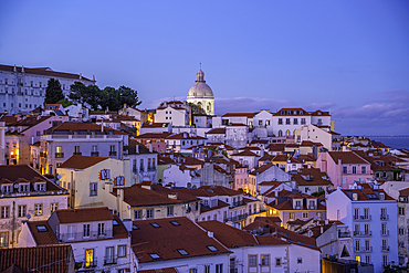 View of colourful buildings and red rooftops at dusk in the Alfama District, Lisbon, Portugal, Europe