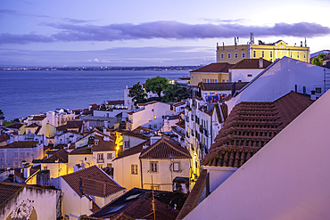 View of colourful buildings and red rooftops at dusk in the Alfama District, Lisbon, Portugal, Europe
