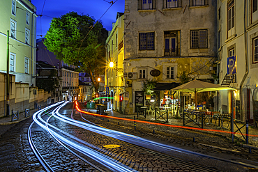 View of cafe and bar with trail lights at dusk in the Alfama District, Lisbon, Portugal, Europe