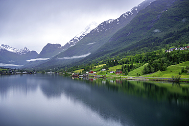 View of Olden village and mountains reflecting in Nordfjorden during summer, Norway, Scandinavia, Europe