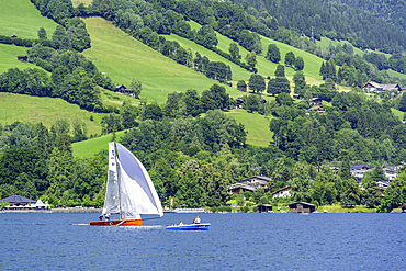 View of boat on Lake Zell from Zell am See and mountainous backdrop on a sunny day, Zell am See, Salzburg, Austria, Europe