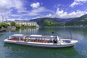 View of the Grand Hotel, tour boat and Lake Zell in Zell am See on a sunny day, Zell am See, Salzburg, Austria, Europe