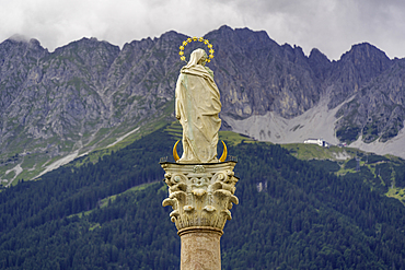 View of Virgin Mary on Annasäule in the old town with mountainous backdrop in summer, Innsbruck, Tyrol Region, Austria, Europe