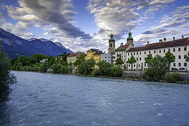View of St. Jakob Cathedral, colourful buildings and River Inn during golden hour in summer, Innsbruck, Tyrol Region, Austria, Europe