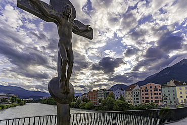View of Rudi Wach Kreuz sculpture on bridge and colourful buildings at sunset in summer, Innsbruck, Tyrol Region, Austria, Europe