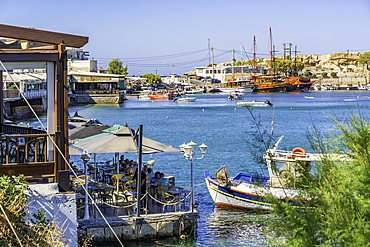 View of seaside taverna and bar with Port of Hersonissos in background, Limenas Chersonisou, Crete, Greek Islands, Greece, Europe
