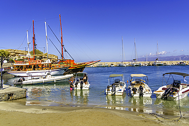 View of boats and small beach in Port of Hersonissos, Limenas Chersonisou, Crete, Greek Islands, Greece, Europe