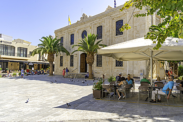 View of Cathedral Holy Temple of Saint Titus and cafe on a sunny day, City of Heraklion, Crete, Greek Islands, Geece, Europe