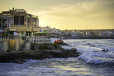 View of taverna overlooking the sea in Limenas Chersonisou at sunset, Crete, Greek Islands, Greece, Europe