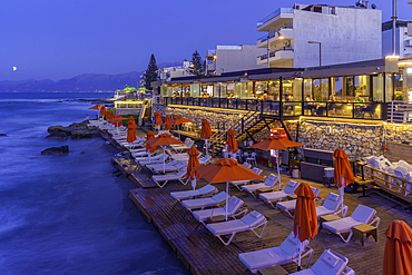 View of taverna overlooking the sea in Limenas Chersonisou at dusk, Crete, Greek Islands, Greece, Europe