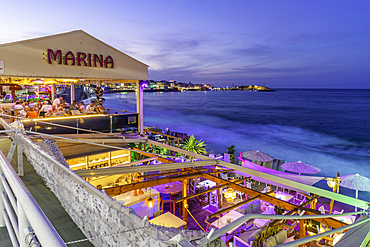 View of taverna overlooking the sea in Limenas Chersonisou at dusk, Crete, Greek Islands, Greece, Europe