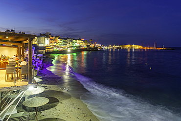 View of beach and town overlooking the sea in Limenas Chersonisou at dusk, Crete, Greek Islands, Greece, Europe