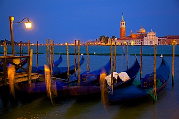 Gondolas moored on the Lagoon, San Giorgio Maggiore beyond, Riva degli Schiavoni at dusk, Venice, UNESCO World Heritage Site, Veneto, Italy, Europe