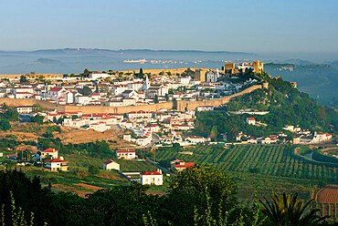 View of old town and castle walls in dawn mist, Obidos, Estremadura, Portugal, Europe