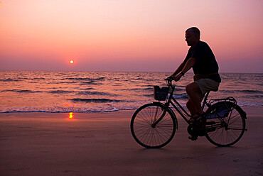 Sunset and cyclist, Goa, India, Asia