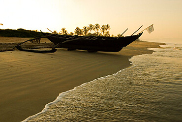 Sunrise over traditional fishing boat and beach, Benaulim, Goa, India, Asia