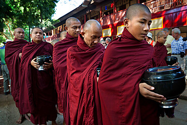 Buddhist monks lining up to receive donations of rice for lunch, Mahar Gandar Yone Monastery, Mandalay, Myanmar (Burma), Asia