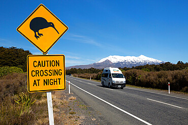 Motorhome below Mount Ruapehu with Kiwi crossing sign, Tongariro National Park, UNESCO World Heritage Site, North Island, New Zealand, Pacific