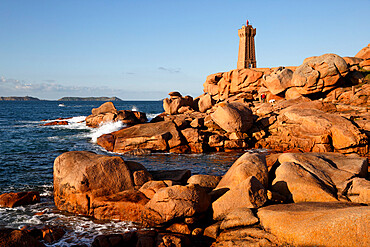 Lighthouse and pink rocks at sunset, Ploumanach, Cote de Granit Rose, Cotes d'Armor, Brittany, France, Europe