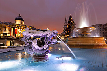 Trafalgar Square at Christmas in snow at night, London, England, United Kingdom, Europe