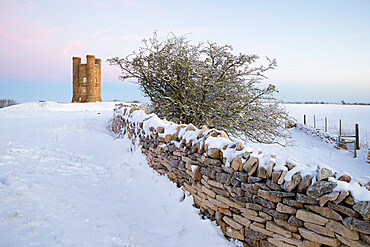 Broadway Tower and dry stone wall in winter snow, Broadway, The Cotswolds, Worcestershire, England, United Kingdom, Europe