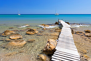 Wooden pier and clear turquoise sea with yachts at Provatas beach, Milos, Cyclades, Aegean Sea, Greek Islands, Greece, Europe