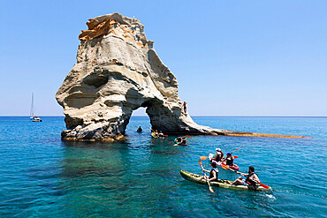 Kayakers go through arch rock formation with crystal clear water, Kleftiko, Milos, Cyclades, Aegean Sea, Greek Islands, Greece, Europe