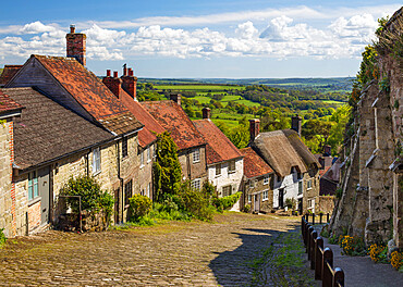 Gold Hill, cobbled lane lined with cottages and views over countryside, Shaftesbury, Dorset, England, United Kingdom, Europe