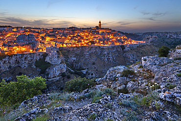 Dusk over the Gravina River canyon and the floodlit Sassi di Matera old town, Matera, Basilicata, Italy, Europe