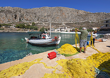 Fishermen mending nets on the quayside, Gerolimenas, Mani, Peloponnese, Greece, Europe